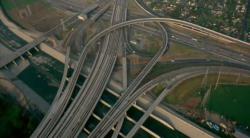 Freeway interchange, possibly in Los Angeles judging by the concrete flood-divert (LA River?) at the
