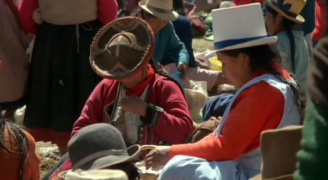 These womans are from Cusco, Peru. The white hated, is from the city ("mestiza") and the other, from the highlands. The scene may be at a sunday market, in Pisac, 40 km. from Cusco.